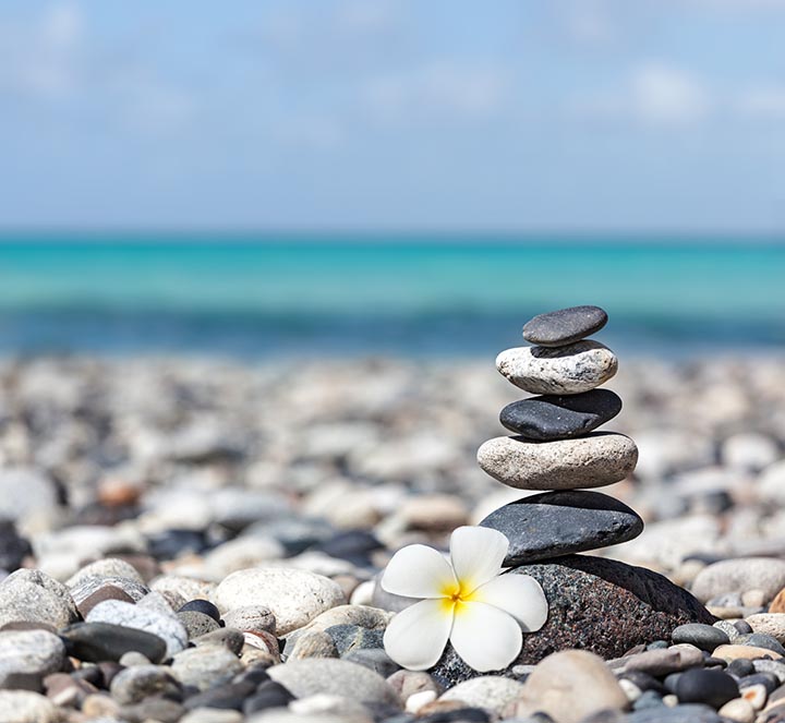 Stone-Cairn-flower-ocean-peaceful-balance-ca109903193-copy