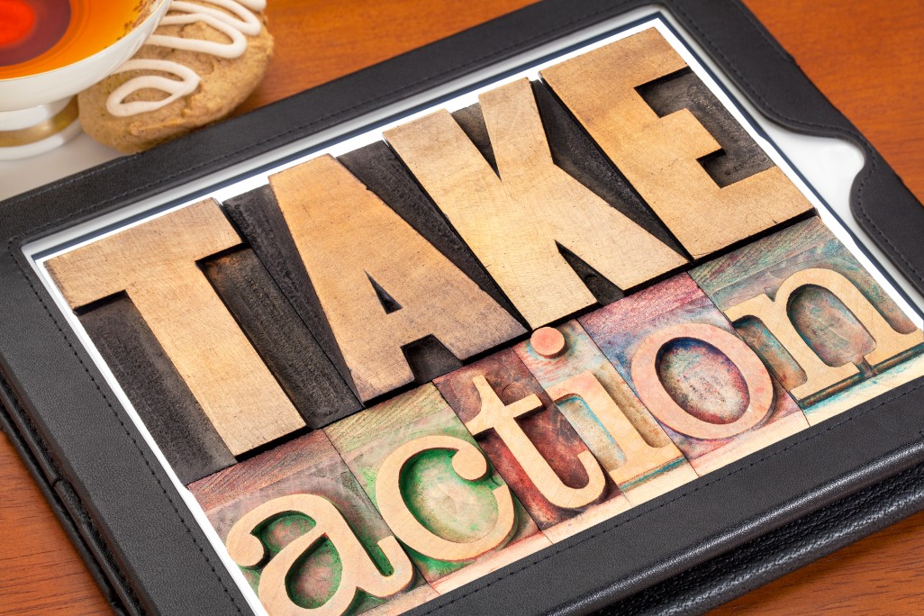 Take action - motivation concept - text in vintage letterpress wood type on a digital tablet